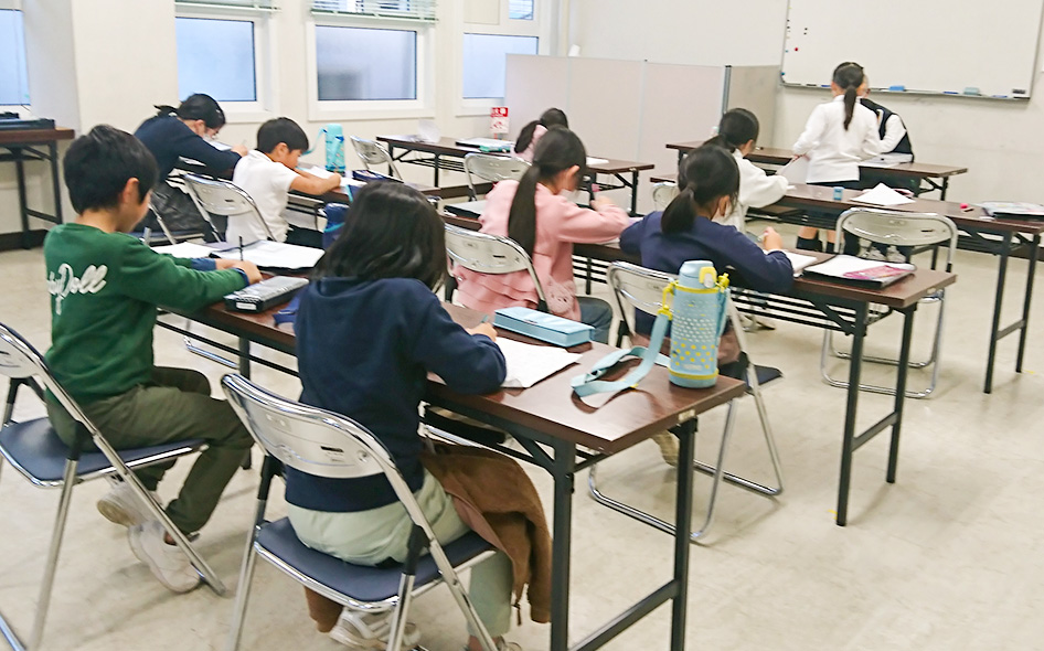 画像：教室でお手本を書き取る生徒